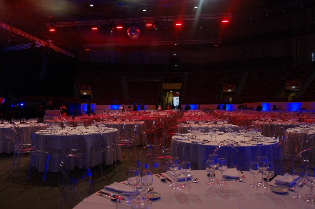 jantar de natal corporativo no campo pequeno em losboa. mesas redondas postas e luzes coloridas a decorar o espaço. decoração de evento.