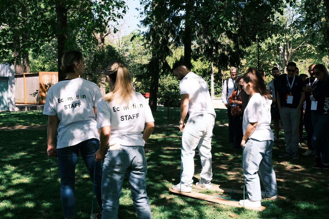 Equipa Ecomotion a demonstrar atividade de team building com jogos tradicionais nos jardins do palácio de cristal no Porto.