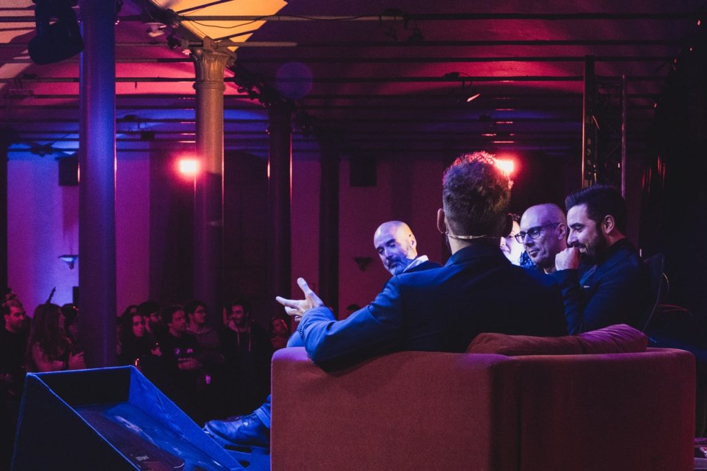grupo de pessoas sentadas em poltronas num palco em  jantar de empresa na alfândega do porto. animção de eventos.