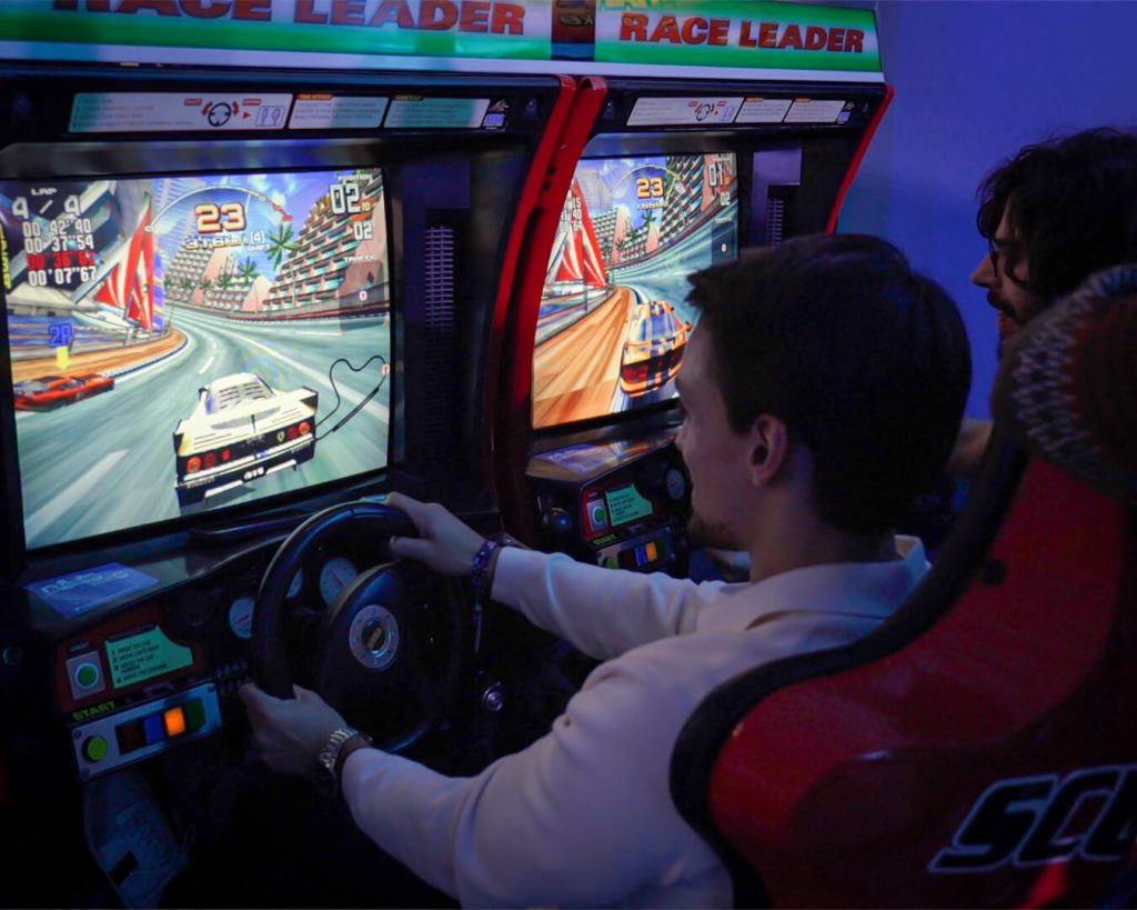 Funcionários BLIP a jogar em máquina simulador de carros. Jogos eventos. Arcade Eventos. Aluguer Arcade. Aluguer Simulador de Carro. Atividades evento. Evento corporativo. Jantar de Natal de empresa.