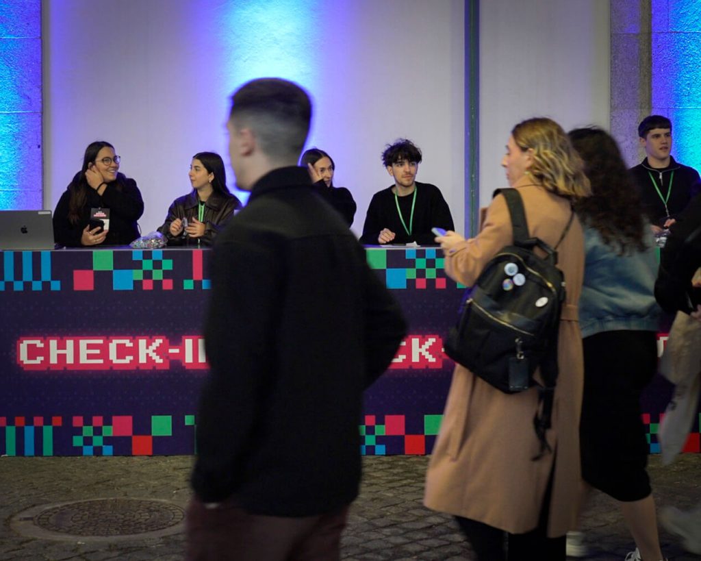 Grupo de funcionários Blip a entrar em evento de natal. Balcões de Check-in personalizados. Branding. Hospedeiras. Evento corporativo. Jantar de Natal de empresa.
