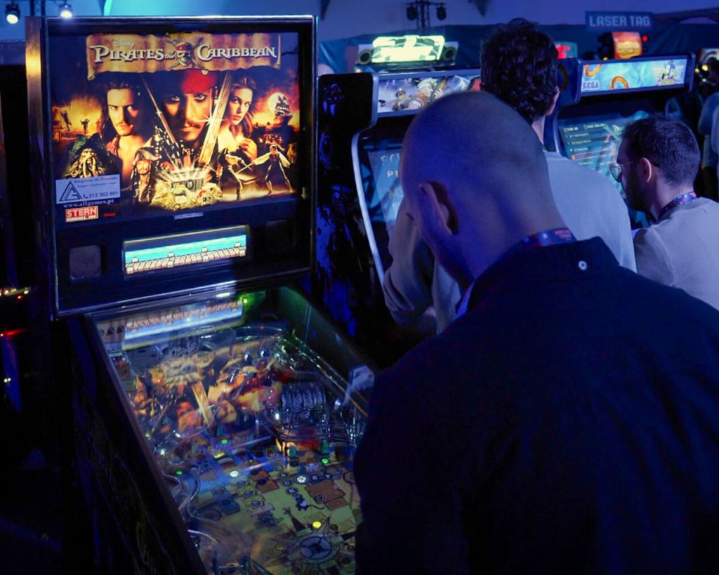 Funcionário BLIP a jogar em máquina flipper. Jogos eventos. Arcade Eventos. Aluguer Arcade. Atividades evento. Evento corporativo. Jantar de Natal de empresa.