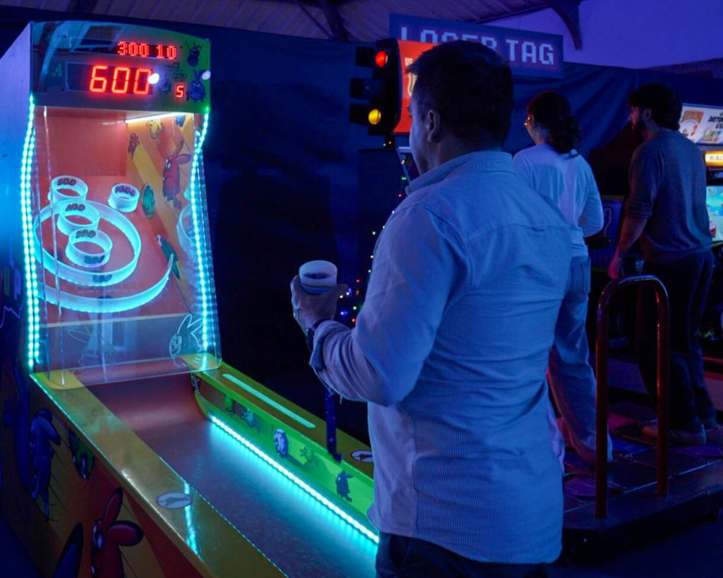 Funcionário BLIP a jogar Skeeball. Jogos eventos. Arcade Eventos. Aluguer Arcade. Atividades evento. Evento corporativo. Jantar de Natal de empresa.